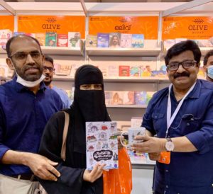Fatima Sherin wafiyya receives author’s signed copy of ഹിന്ദിന്റെ ഇതിഹാസം and the ‘Ithihaasam’ mug from Dr. MK Muneer, at the Olive Books stall in Sharjah international Book Fair. 