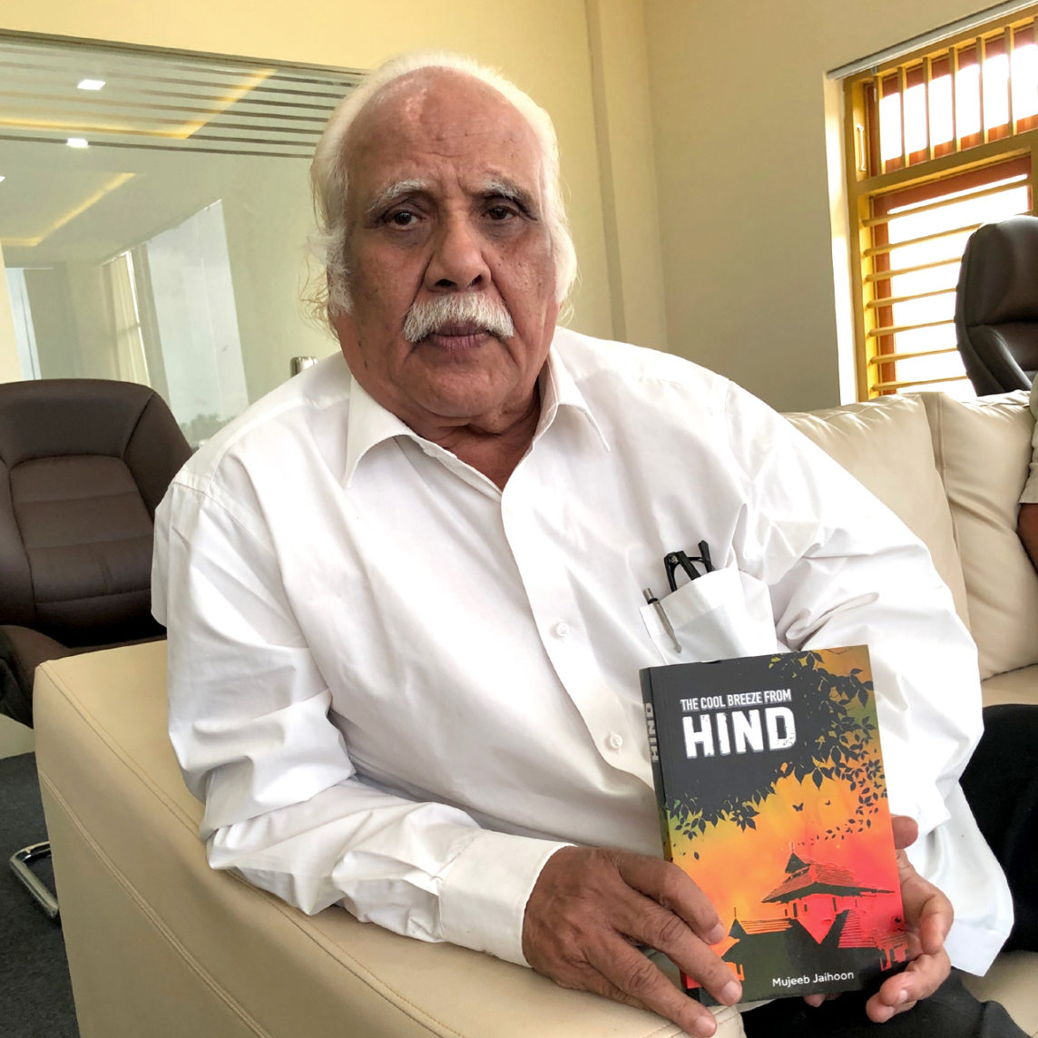 KKN Kurup holding The Cool Breeze From Hind, historical fiction by Mujeeb Jaihoon